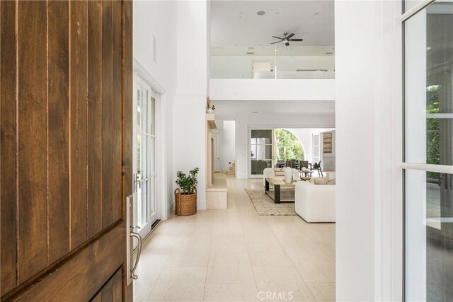 entrance foyer with french doors, a towering ceiling, and ceiling fan