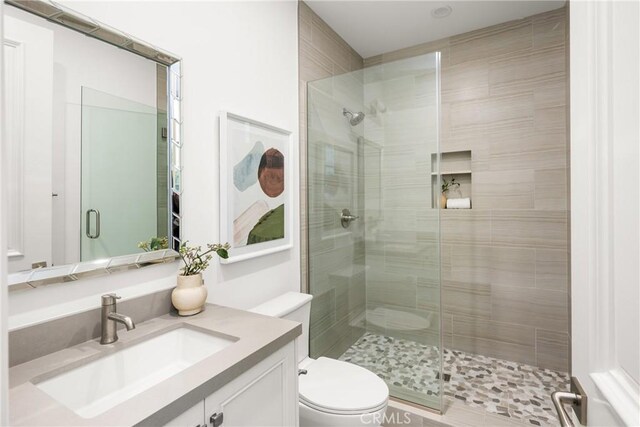 full bath with toilet, a shower stall, and vanity