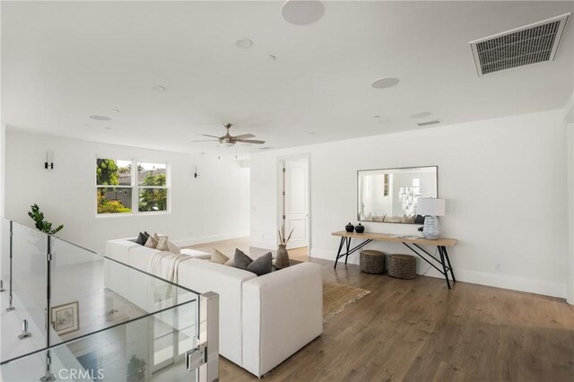 living room featuring baseboards, ceiling fan, wood finished floors, and visible vents