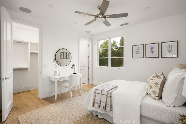 bedroom with baseboards, visible vents, a spacious closet, and light wood-style floors