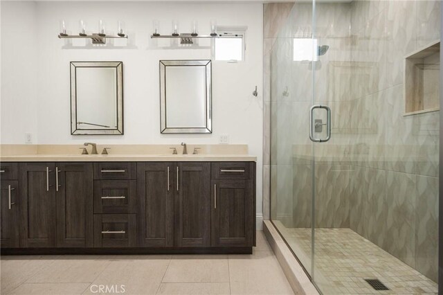 full bathroom with double vanity, a sink, tile patterned flooring, and a stall shower