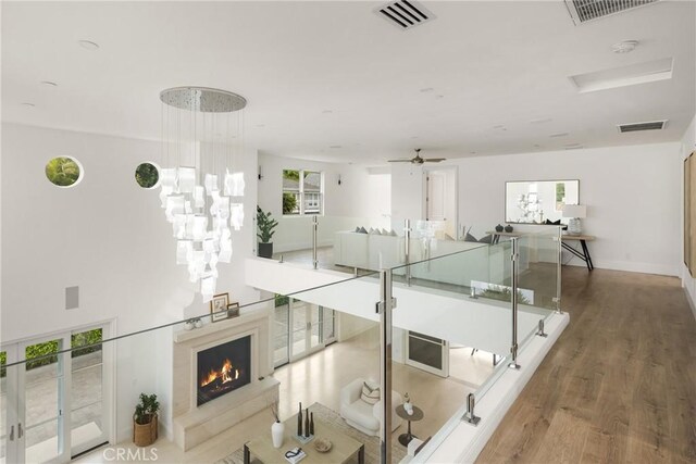 hall featuring baseboards, visible vents, and wood finished floors