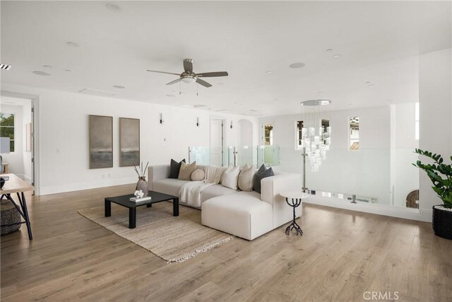 living room with a ceiling fan, baseboards, visible vents, and wood finished floors