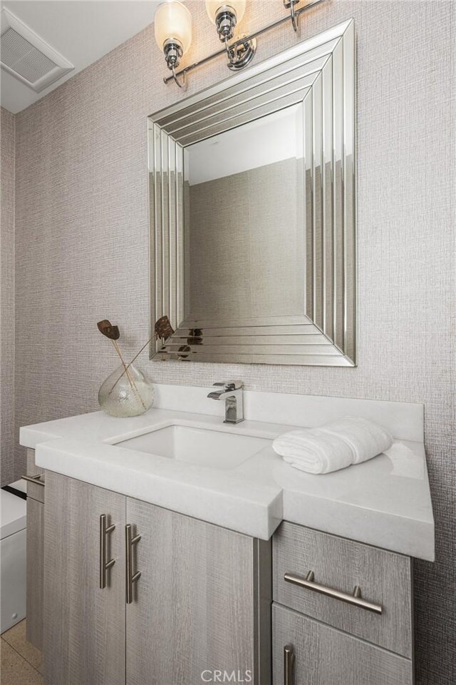 half bathroom with visible vents, toilet, and vanity
