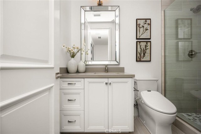 bathroom featuring vanity, a stall shower, and toilet