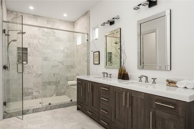 full bath with a sink, a shower stall, recessed lighting, and double vanity