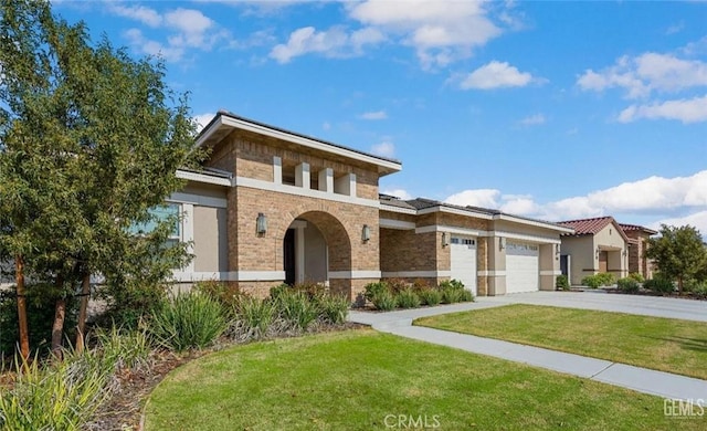 view of front of house featuring a front yard, a garage, driveway, brick siding, and stucco siding