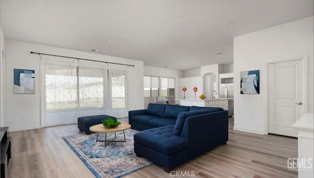 living area featuring baseboards and light wood-style flooring