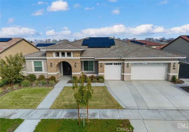 mediterranean / spanish house featuring a garage, stucco siding, driveway, and a front yard