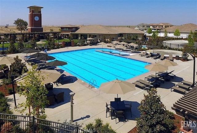 community pool with a residential view, a patio, and fence