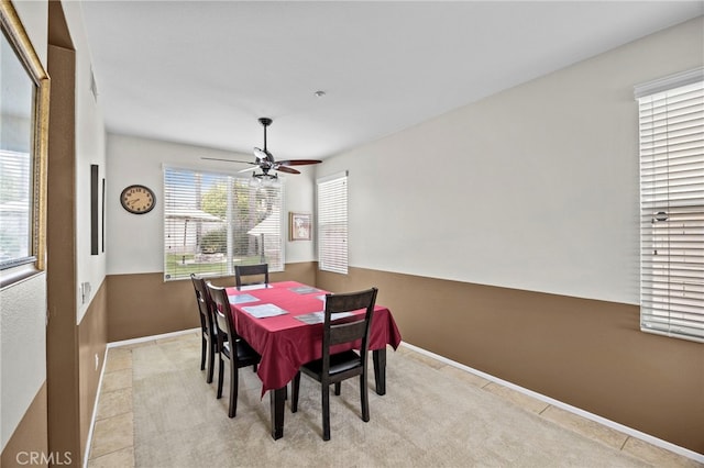 dining space featuring baseboards, ceiling fan, and light tile patterned flooring