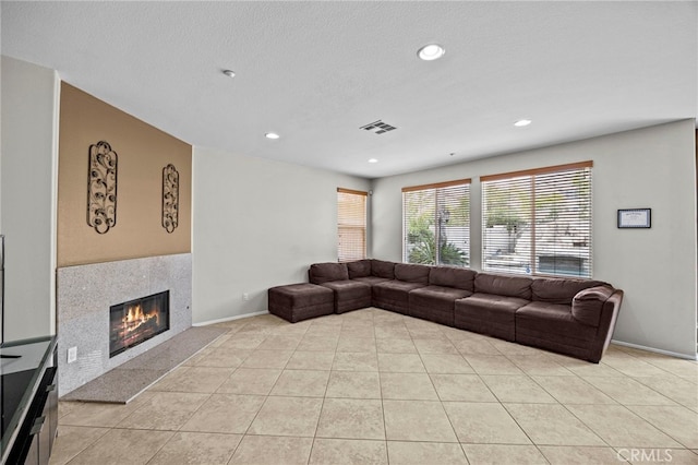 living room with visible vents, a tile fireplace, baseboards, recessed lighting, and light tile patterned flooring