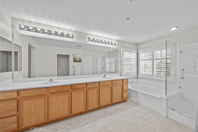 bathroom featuring a garden tub, a sink, double vanity, and a shower stall