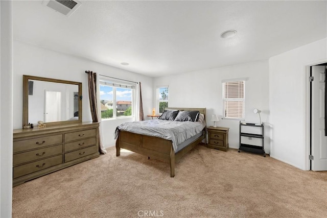carpeted bedroom featuring visible vents