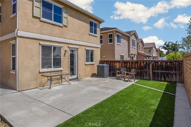 back of property with cooling unit, a residential view, a lawn, stucco siding, and a fenced backyard