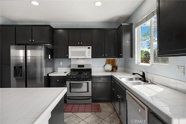 kitchen featuring light tile patterned flooring, tile counters, and stainless steel appliances