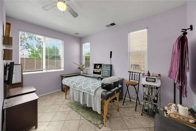 interior space featuring light tile patterned floors, a ceiling fan, visible vents, and baseboards
