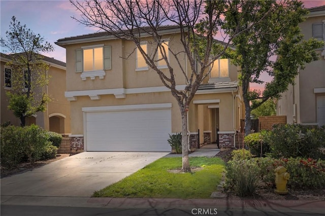 view of front of home with an attached garage, concrete driveway, stone siding, and stucco siding