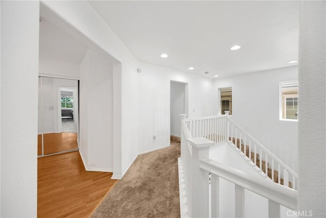 hall featuring light wood-style floors, recessed lighting, an upstairs landing, and baseboards