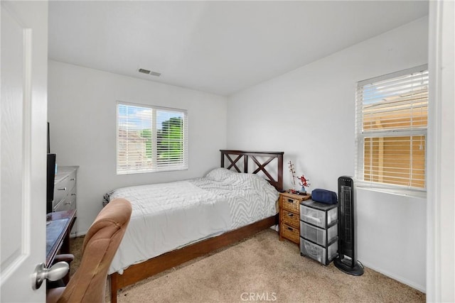 carpeted bedroom featuring baseboards and visible vents