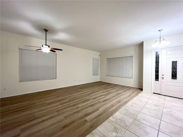 22810 Mountain Ash Cir, Corona, CA 92883 - interior space featuring baseboards, ceiling fan with notable chandelier, and light wood finished floors
