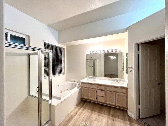 22810 Mountain Ash Cir, Corona, CA 92883 - bathroom featuring wood finished floors, a tub with jets, double vanity, a sink, and a stall shower