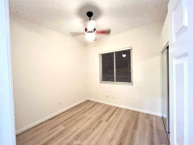 22810 Mountain Ash Cir, Corona, CA 92883 - empty room featuring light wood finished floors, a textured ceiling, ceiling fan, and baseboards