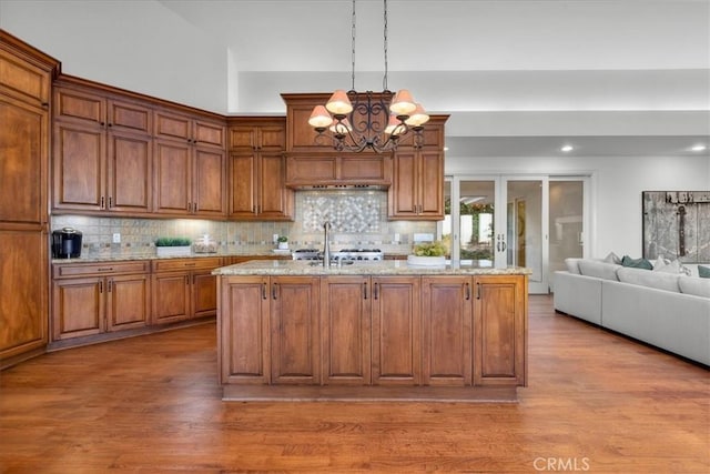 12 Bowie Rd, Rolling Hills, CA 90274 - kitchen featuring a chandelier, wood finished floors, light stone countertops, decorative backsplash, and recessed lighting