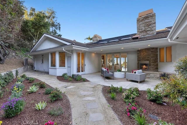 12 Bowie Rd, Rolling Hills, CA 90274 - rear view of house featuring a chimney, a patio, stucco siding, and an outdoor living space with a fireplace