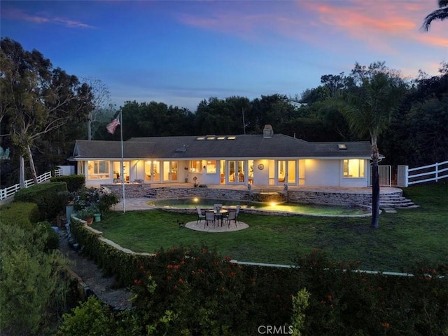 12 Bowie Rd, Rolling Hills, CA 90274 - back of house at dusk with a fire pit, a patio, and stucco siding