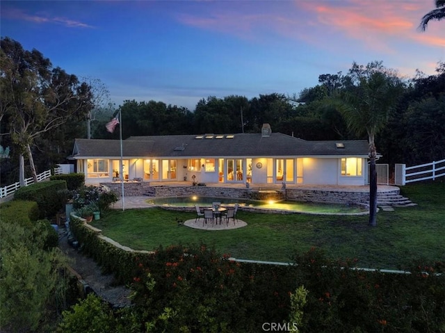 12 Bowie Rd, Rolling Hills, CA 90274 - back of house at dusk with an outdoor fire pit, a patio, a fenced backyard, and stucco siding