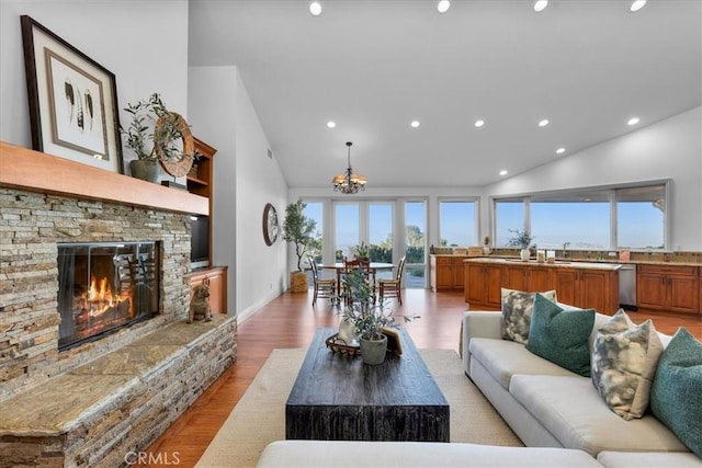 12 Bowie Rd, Rolling Hills, CA 90274 - living room featuring recessed lighting, light wood finished floors, a chandelier, high vaulted ceiling, and a stone fireplace