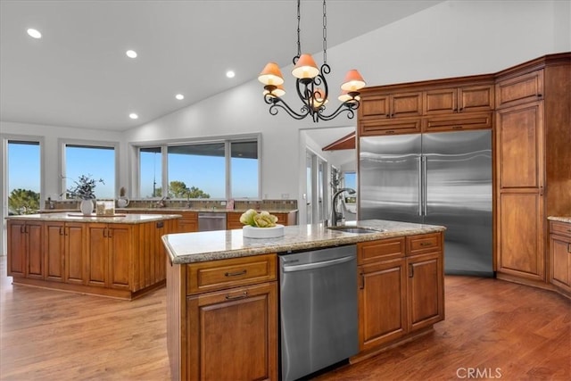 12 Bowie Rd, Rolling Hills, CA 90274 - kitchen featuring appliances with stainless steel finishes, a sink, an island with sink, brown cabinetry, and high vaulted ceiling