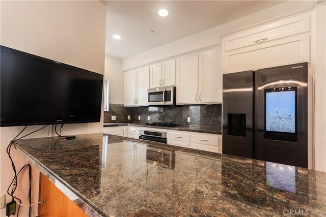 1020 Hilldale Ave, West Hollywood, CA 90069 - kitchen with decorative backsplash, recessed lighting, white cabinetry, dark stone countertops, and stainless steel appliances
