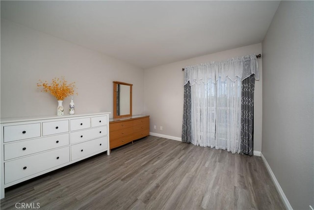 bedroom featuring baseboards and wood finished floors