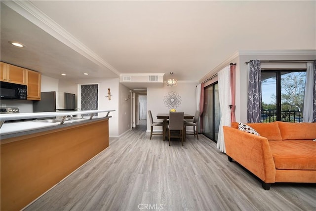 living area with visible vents, baseboards, light wood finished floors, ornamental molding, and recessed lighting