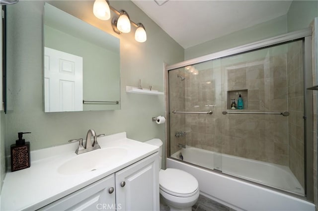 full bath with vanity, bath / shower combo with glass door, and toilet