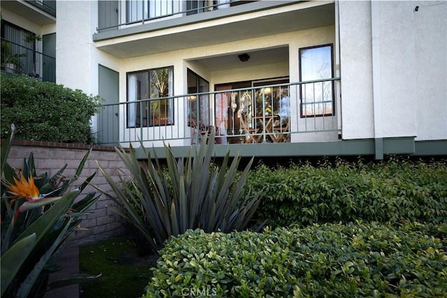 exterior space with stucco siding and a balcony