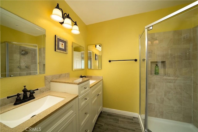 full bath with vanity, baseboards, and a stall shower