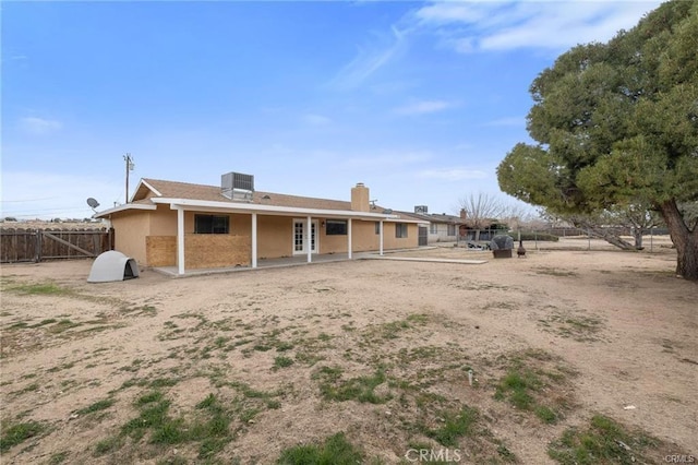 rear view of property with cooling unit, a chimney, a patio area, stucco siding, and fence