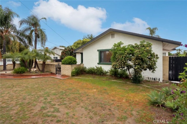 4447 Walnut Ave, Chino, CA 91710 - exterior space with stucco siding, fence, a gate, and a lawn