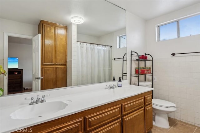4447 Walnut Ave, Chino, CA 91710 - bathroom featuring tile walls, toilet, tile patterned flooring, and a sink