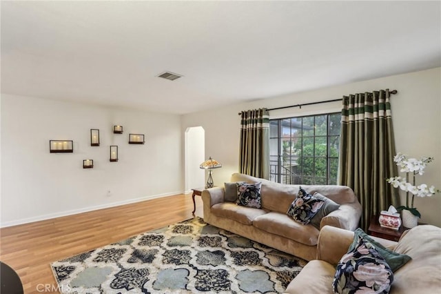 4447 Walnut Ave, Chino, CA 91710 - living room featuring wood finished floors, visible vents, arched walkways, and baseboards