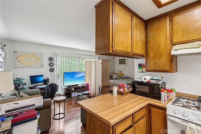 4447 Walnut Ave, Chino, CA 91710 - kitchen with black microwave, white range with gas cooktop, under cabinet range hood, open floor plan, and dark wood-style flooring
