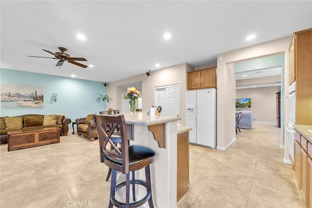 19069 Eldorado Rd, Perris, CA 92570 - kitchen featuring white refrigerator with ice dispenser, a kitchen breakfast bar, light countertops, recessed lighting, and a center island