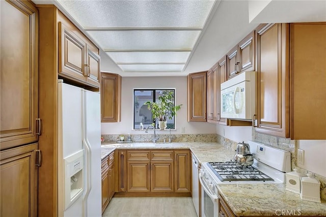 21650 Burbank Blvd Unit 111, Woodland Hills, CA 91367 - kitchen featuring a sink, light wood-type flooring, white appliances, and brown cabinets