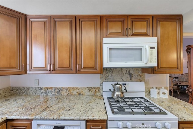 21650 Burbank Blvd Unit 111, Woodland Hills, CA 91367 - kitchen with light stone countertops, brown cabinets, and white appliances