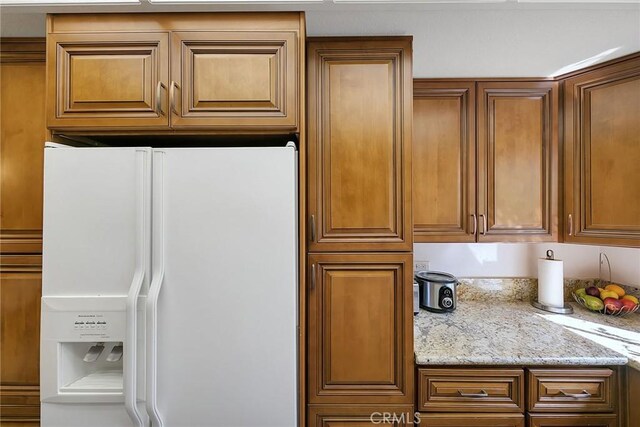 21650 Burbank Blvd Unit 111, Woodland Hills, CA 91367 - kitchen featuring light stone counters, white refrigerator with ice dispenser, and brown cabinets