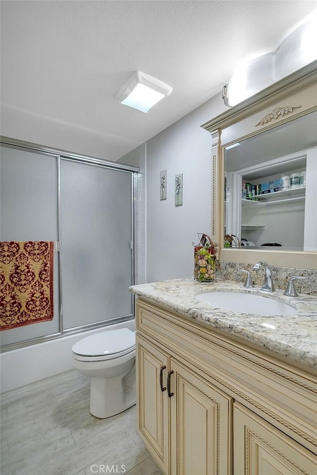 21650 Burbank Blvd Unit 111, Woodland Hills, CA 91367 - full bathroom with wood finished floors, enclosed tub / shower combo, toilet, and vanity