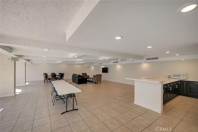21650 Burbank Blvd Unit 111, Woodland Hills, CA 91367 - kitchen with light tile patterned floors, white microwave, beam ceiling, and visible vents